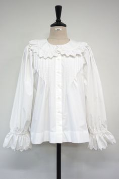 Long sleeve cotton blouse with ruffle detail on the shawl collar. Flared ruffled cuff and loose comfy fit, make this blouse to die for. Model is in MINUSEY ONE SIZE. Please allow 5-12 days shipping when in restocking. * MINUSEY ONE SIZE = EU 34-38, US 2-6* 100% Cotton* Dry clean* Made in Korea - Model Height: 170cm/5'7" (US2, EU34) Fall Cotton Blouse With Lace Collar, Cotton Blouse With Lace Collar For Fall, Classic Cotton Blouse With Ruffles, Ruffled Long Sleeve Relaxed Fit Blouse, Long Sleeve Ruffled Blouse With Relaxed Fit, Long Sleeve Ruffle Blouse With Relaxed Fit, Relaxed Fit Long Sleeve Ruffled Blouse, Feminine Cotton Blouse With Smocked Cuffs, Long Sleeve Tops With Detachable Collar For Daywear