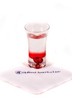 a glass filled with liquid sitting on top of a napkin