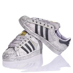 Adidas Superstar Bright Silver is the custom delicate and bold women's sneaker. Completely washed in silver with a white and silver glitter back and eyelets and gray satin laces. &nbsp;Adidas Superstar Bright Silver will also come with its original white laces. Metallic Sneakers With Laces For Streetwear, Metallic High-top Sneakers With Speckled Midsole, Metallic Low-top Sneakers With Speckled Midsole, Silver Lace-up Sneakers With Vulcanized Sole, Metallic Sneakers With Speckled Midsole For Streetwear, Silver High-top Sneakers With Vulcanized Sole, Silver Sneakers For Streetwear With Speckled Midsole, Silver Sneakers With Speckled Midsole For Streetwear, Silver High-top Sneakers With Glitter Accents