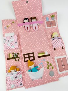 a doll house made out of pink fabric with dolls on the top and bottom floor