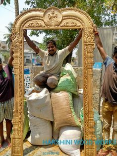 two men standing next to a large pile of sandbags in front of a gold frame