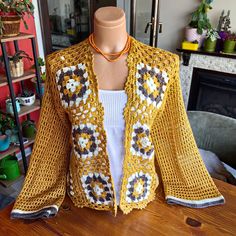 Embrace the sunny days with our Handmade Yellow Crochet Cardigan, a perfect blend of bohemian charm and summer elegance. This lightweight cardigan is meticulously hand-knitted from soft acrylic yarn, offering a breezy yet stylish option for your summer wardrobe. Elegant Design and Craftsmanship: Experience the unique beauty of our floral pattern crochet cardigan, crafted in vibrant mustard yellow hues that add a touch of sunshine to any outfit. The intricate hand-knit detailing showcases the ski Bohemian Crochet V-neck Cardigan, Bohemian V-neck Crochet Cardigan, Bohemian Crochet Cardigan For Vacation, Bohemian Crochet V-neck Top For Fall, Casual Crochet Lace Cardigan For Beach, Bohemian V-neck Crochet Top For Fall, Fall Bohemian V-neck Crochet Top, Fitted Bohemian Cardigan For Summer, Handmade Bohemian Crochet Long Sleeve Top