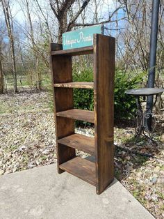 a wooden book shelf sitting on top of a sidewalk