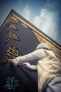 a man is painting the side of a building with gold and black designs on it