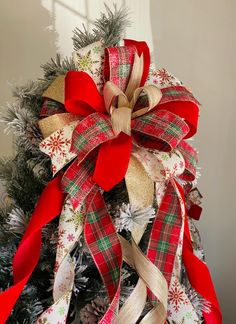 a christmas tree decorated with red, white and gold ribbons