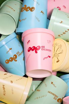 ice cream cups are stacked on top of each other in pastel and gold colors