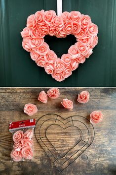 a heart shaped wreath with pink roses next to it