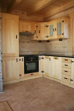 an empty kitchen with wooden cabinets and black counter tops, is seen in this image