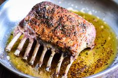 a piece of meat sitting on top of a pan covered in oil and seasoning