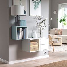 a living room filled with furniture next to a wall mounted book shelf on the side of a wall