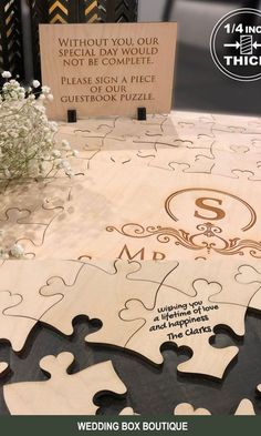 a wooden puzzle with the words wedding box boutique on it and flowers in vase next to it