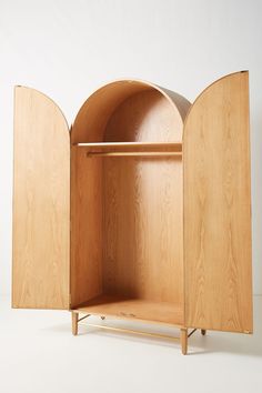 an open wooden cabinet sitting on top of a white floor