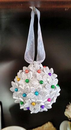 a white ornament hanging from a table with other dishes and food on it