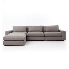 a grey sectional couch with pillows on it's back and the seat folded out