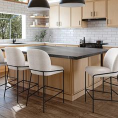 a kitchen with wooden cabinets and white chairs in front of an island counter topped with black marble top