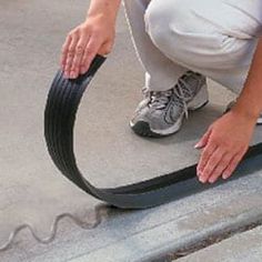 a man is working on the side of a building with a hose attached to it