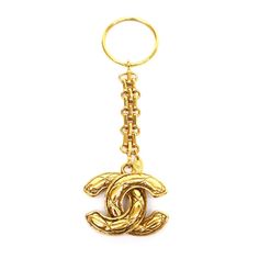 a gold key chain with a chandelier charm on the front and back ends