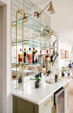 a bar with lots of bottles and glasses on top of it, sitting in the middle of a room