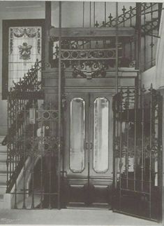 an old black and white photo of a staircase in a building with glass doors on each side