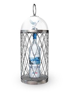 a bottle in a cage with a bird on it's top and the bottom