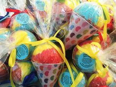 several plastic cups filled with candy and wrapped in cellophane, tied with yellow ribbon