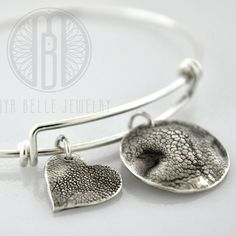 Made from your pet's actual nose (or paw) prints... This listing is for one small (~16 mm) dog nose charm and one large (~21 mm) paw print charm; both in pure, solid silver (.999). Our bangles are anti-tarnish sterling silver and they come in 2 sizes (7" adjustable bangle and 8.5" adjustable bangle). Add your dog's name or initials on the back of the charm as an engraving for FREE (optional) **Includes Free Shipping of the mold kit which includes a prepaid return label (US only) as well as mold Dog Nose Print, Paw Print Charm, Dog Nose, Silver Diamond Necklace, Mold Kit, Silver Bangle Bracelet, Sterling Silver Bangle Bracelets, Jewelry Bracelets Silver, Sterling Silver Bangle