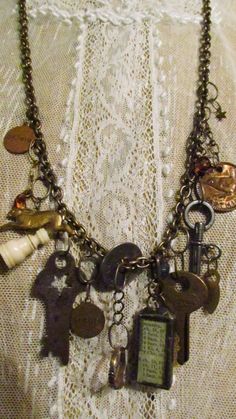 the necklace has many charms on it and is attached to a chain with an antique key