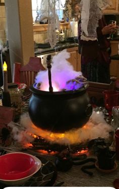 a large pot with steam coming out of it sitting on top of a table in a kitchen