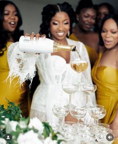 a woman pouring champagne into wine glasses with other women in yellow dresses behind her and another woman standing next to her