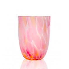 a pink and yellow vase sitting on top of a table