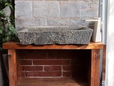 a stone sink sitting on top of a wooden shelf