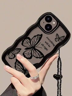 a person holding up a cell phone case with butterflies on the front and back cover