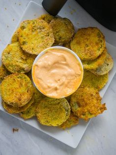 an appetizer is served on a plate with some dipping sauce in the middle