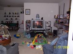 a living room filled with furniture and a flat screen tv sitting on top of a entertainment center