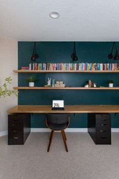 an office with bookshelves and desk in the corner, along with two planters