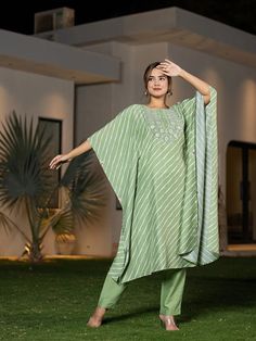 This 2-piece set includes green embroidery & leheriya print kaftan style kurta has round neck, short flared sleeves, flared hem, calf length teamed with solid trouser pants with elasticated waistband & slip on closure. 2 Piece Set Color-Green Kurta Fabric- Silk Blend Work - Thread Work Embroidery & Leheriya Print Detailing Neck - Round Neck Sleeves - Short Flared Sleeves Length-Calf Length Pocket - Single Pocket Bottom - Solid Trouser Pants Size & Fit - Elasticated Waistband Bottom - Slip-on Closure Washing Care-Hand Wash The model height 5'8 is wearing a size small Festive Green Dabka Kaftan, Spring Green Embroidered Palazzo Set, Green Palazzo Set With Dabka Work For Spring, Green Anarkali Kaftan With Dabka Work, Green Resham Embroidered Kaftan For Diwali, Pista Green Straight Kurta Anarkali Set For Spring, Bollywood Style Spring Kaftan With Dabka Work, Spring Bollywood Kaftan With Dabka Work, Bollywood Style Dabka Work Kaftan For Spring