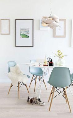 a dining table with four chairs and a white rug on the floor in front of it