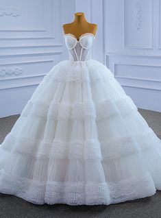 a white wedding dress on display in a room