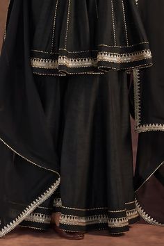 Black short anarkali, edged with kinari and embellished with border. Comes with matching sharara and dupatta edged with kinari.
Components: 3
Pattern: Embroidered
Type Of Work: Kinari
Neckline: Round
Sleeve Type: Full
Fabric: Anarkali and Sharara- Raw Silk, Dupatta- Organza
Color: Black
Other Details: 
Disclaimer: The actual print-placement and colour of the product may vary slightly from the image shown.
Occasion: Sangeet - Aza Fashions Black Traditional Drape Palazzo Set For Navratri, Black Palazzo Set With Dupatta For Navratri, Festive Bollywood Black Palazzo Set, Black Anarkali Palazzo Set With Traditional Drape, Black Anarkali Palazzo Set, Black Palazzo Set With Dupatta In Traditional Drape, Black Anarkali Palazzo Set For Diwali, Black Anarkali Style Palazzo Set For Diwali, Black Bollywood Palazzo Set With Dupatta