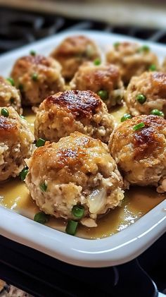 some meatballs with sauce and green onions on a plate