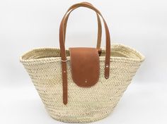 Step into the warm embrace of summer with our handcrafted tote bag, designed to pair seamlessly with your sun-kissed adventures. Meticulously woven from durable, eco-friendly straw, this tote features an expansive interior to carry all your essentials - whether you're hitting the beach or browsing the local farmers' market. Accented with a pristine white leather flap and matching straps, it exudes a timeless elegance that complements any outfit. Lightweight yet sturdy, it's your perfect companio Natural Woven Straw Tote Bag, Natural Woven Double Handle Beach Bag, Natural Straw Tote Bag, Travel Beach Bag Woven From Palm Leaf, Woven Palm Leaf Beach Bag For Travel, Natural Woven Beach Bag For Daily Use, Casual Palm Leaf Travel Beach Bag, Natural Palm Leaf Beach Bag For Travel, Palm Leaf Bags For Everyday Beach Use