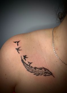 a woman's back with birds flying around her tattoo design on the left shoulder