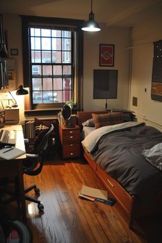 a bed room with a neatly made bed next to a desk and chair in front of a window