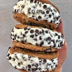 three cookies with white frosting and chocolate chips are stacked on top of each other