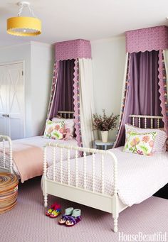 a bedroom with two beds and purple curtains