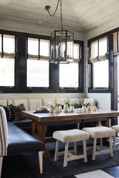 a dining room table with four chairs and two benches in front of the window,