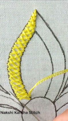 someone is stitching something with yellow thread