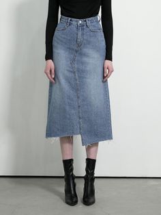 The skirt features a denim skirt with a distinctive split-front design, which gives it a modern and edgy look. The hem of the skirt is frayed, adding to its contemporary styling. It is fitted with a classic five-pocket configuration, with the pockets clearly visible on the front. The waistband includes belt loops and there's a central front closure, likely consisting of a button and a zipper. The skirt's wash has varying shades, giving it texture and visual interest.- The split-front and frayed hem are on-trend details that offer a fresh take on the traditional denim skirt.- The multiple shades within the wash provide the skirt with a dynamic appearance, highlighting its shape and design lines.- The incorporation of the five-pocket design and belt loops allows for practicality and versatil Chic Asymmetrical Medium Wash Denim Skirt, Chic High Waist Skirt With Frayed Hem, Dark Wash Asymmetrical Skirt With Frayed Hem, Spring Pencil Skirt With Frayed Hem, Fitted Denim Asymmetrical Skirt With Frayed Hem, Fitted Denim Pencil Skirt With Frayed Hem, Chic Asymmetrical Skirt In Medium Wash, Fitted Denim Skirt With Frayed Hem And Asymmetrical Shape, Fitted Denim Skirt With Frayed Hem And Asymmetrical Cut