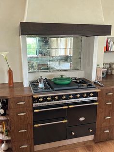 a stove top oven sitting inside of a kitchen next to a wooden cabinet and counter