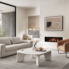 a living room with two couches and a coffee table in front of a fire place